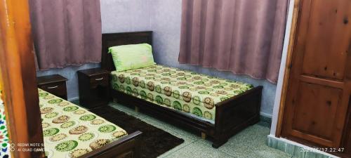 a room with two twin beds in a room at Residence el khannchi in Laayoune