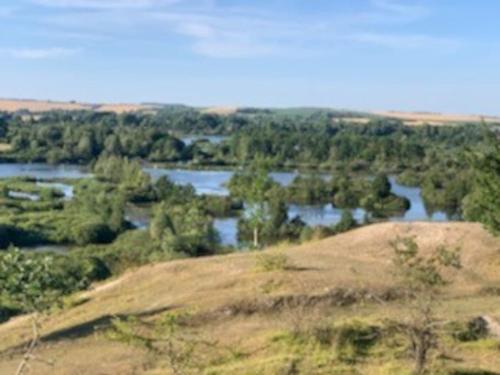 a view of a river from the top of a hill at Gîte Au Crépuscule du Belvédère in Dompierre-Becquincourt
