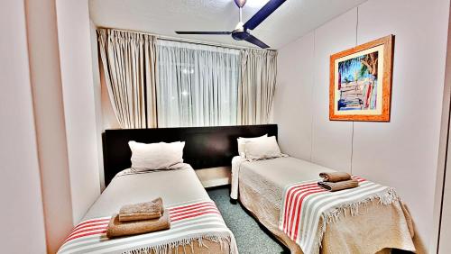 Duas camas num pequeno quarto com uma janela em Summerhill Self-Catering Holiday Accommodation em Plettenberg Bay