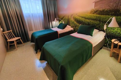 a room with two beds with green sheets and a hedge at Spa Hotel Härmä - Härmän Kylpylä in Ylihärmä