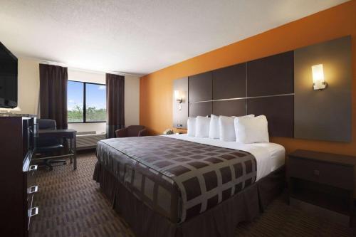 a hotel room with a large bed and a television at Days Inn by Wyndham Los Lunas in Los Lunas