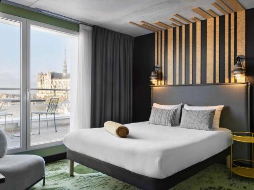1 dormitorio con cama grande y ventana grande en ibis Styles Amiens Centre en Amiens
