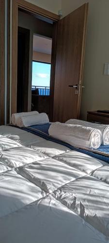 two beds in a hotel room with a window at Blue Seaview Suites in Piraeus