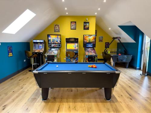 a room with a pool table and arcade games at Canllefaes Cottages in Cardigan