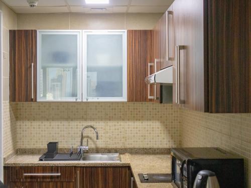 a kitchen with a sink and a window at Cosmos Living Modern Studio Near Dubai Marina in Dubai
