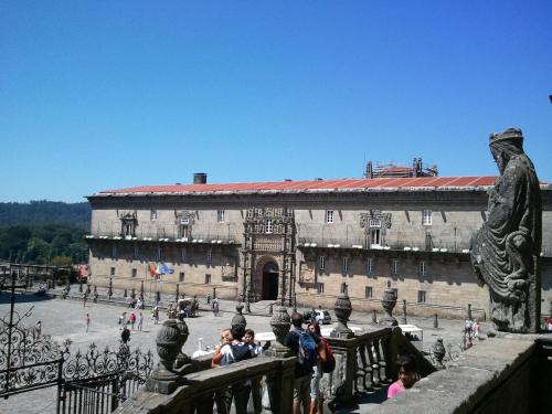 a group of people standing on a bridge in front of a building at Parador de Santiago - Hostal Reis Catolicos in Santiago de Compostela