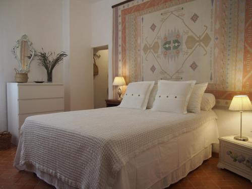 une chambre avec un grand lit avec des oreillers blancs dans l'établissement La Vita Dolce, Luberon, à Grambois