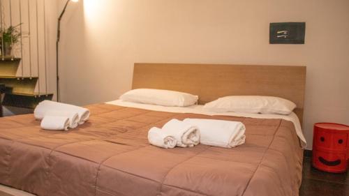 a large bed with two pillows and towels on it at Apollo Suites in Lecce