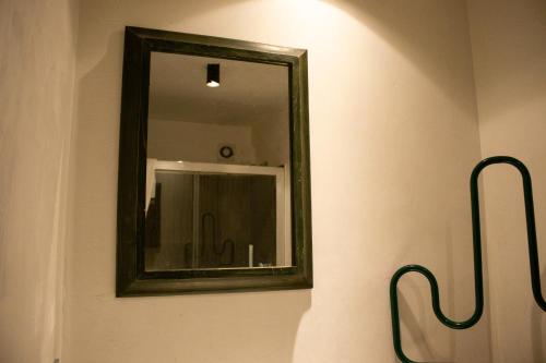 a mirror on a wall next to a sink at Apollo Suites in Lecce
