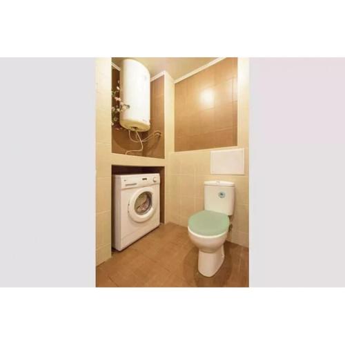 ein Badezimmer mit einem WC und einer Waschmaschine in der Unterkunft Апартаменты на Алчевских 5 in Kharkov