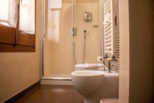 a small bathroom with a toilet and a shower at Apollo Suites in Lecce