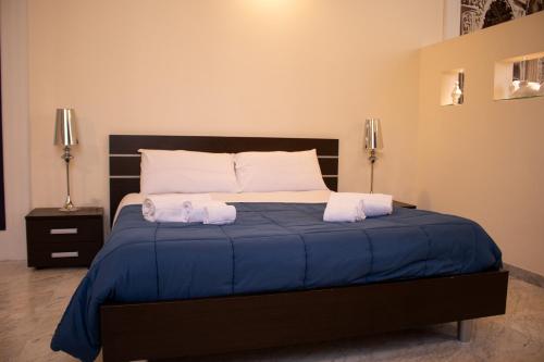a bedroom with a bed with two towels on it at Apollo Suites in Lecce