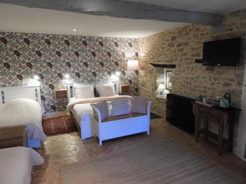 a bedroom with a bed and a couch and a tv at Chambre d'Hôtes les 3 Cochons d'Olt in Arcambal