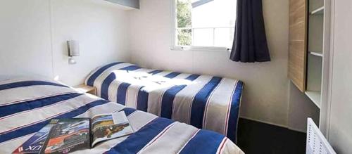 een slaapkamer met 2 bedden en een raam bij VVF Morbihan Larmor-Plage in Larmor-Plage