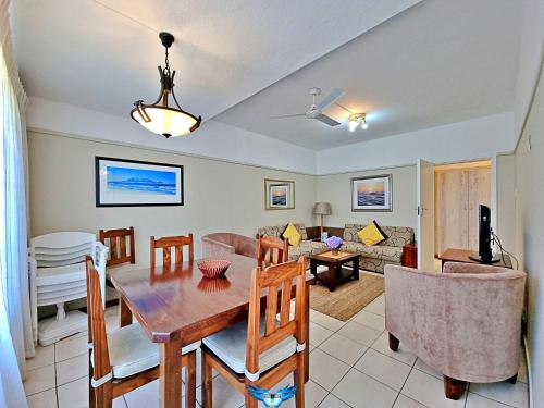 a dining room and living room with a table and chairs at Fairway Holiday Accommodation in Hermanus