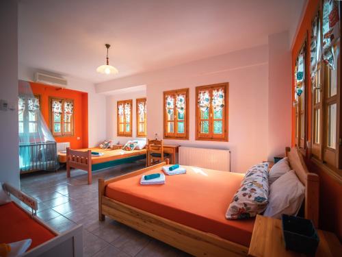 1 dormitorio con 2 camas y sala de estar en Orange House for big families in Damouchari - Delicious Houses, en Damouchari