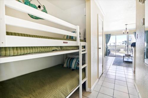 Zimmer mit Etagenbetten und Flur in der Unterkunft Victorian 6106 - Seaside Suite in Galveston