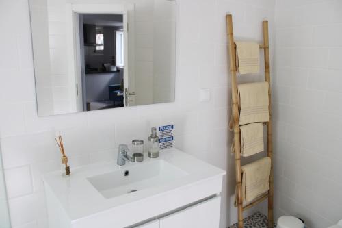 a bathroom with a white sink and a mirror at Casa das Nobres in Évora