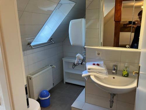 małą łazienkę z umywalką i lustrem. w obiekcie Ferienwohnung 3 ADA w mieście Bergen auf Rügen