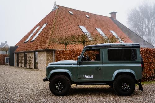 a green jeep parked in front of a house at Uitgerust voor Zaken in Heerenveen