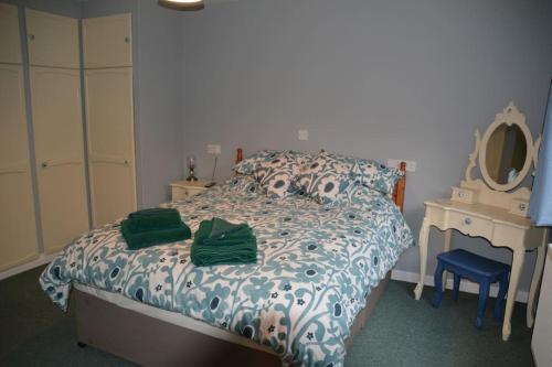 a bedroom with a bed with a dresser and a mirror at The Coach House at Copper Hall in Leominster