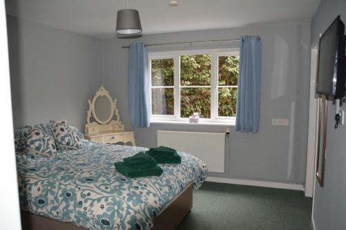 a bedroom with a bed and a window at The Coach House at Copper Hall in Leominster