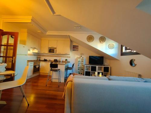 a living room with a couch and a kitchen at El Cielo de Fomento in Gijón