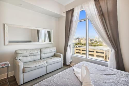 a bedroom with a bed and a couch and a window at Emerald 705 in Galveston