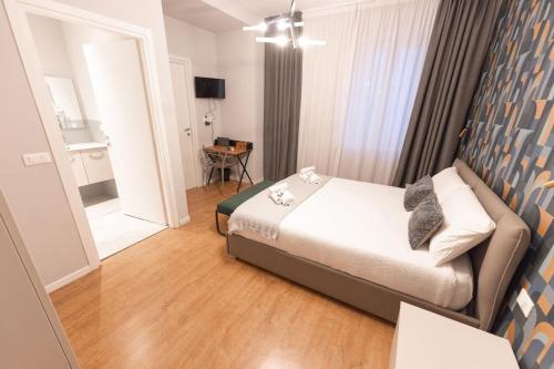 ein kleines Schlafzimmer mit einem Bett und ein Zimmer mit einem Tisch in der Unterkunft Carlo Residence in Triest