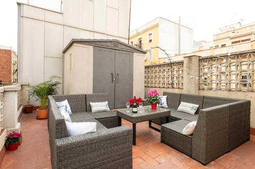 een patio met rieten stoelen en tafels op een balkon bij Barcelona Beach Home in Barcelona
