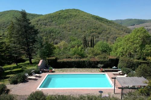 a swimming pool with a mountain in the background at Villa Rosa Panzano in Panzano
