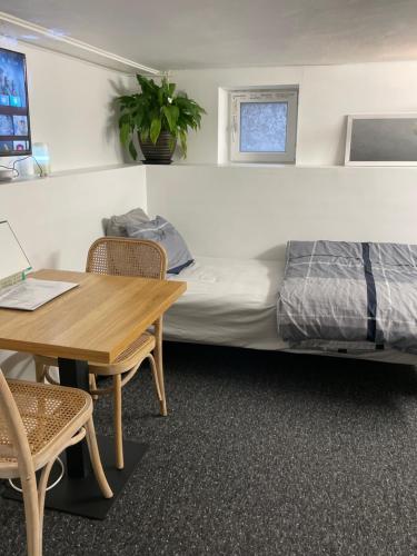 1 dormitorio con cama, escritorio y mesa en Brabo källare, en Landskrona