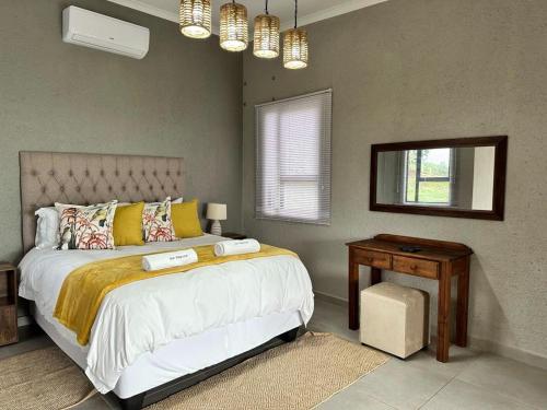 a bedroom with a large bed and a mirror at Hazyview Accommodation, Bon Repose Cottages 3&4 in Hazyview