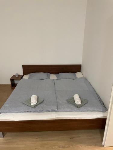 a bedroom with a bed with two hats on it at AA Apartman in Kaposvár