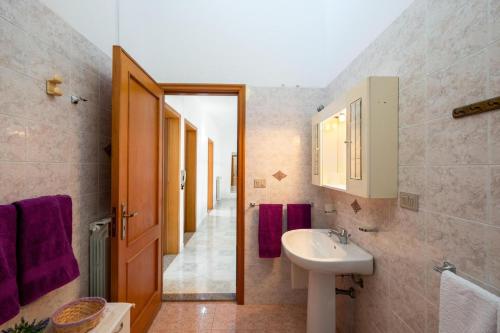 La salle de bains est pourvue d'un lavabo et de serviettes pourpres. dans l'établissement Mary Rose, à Spongano