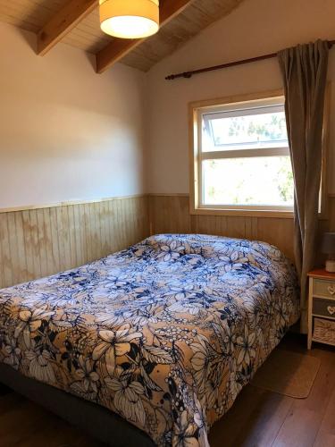 a bedroom with a bed and a window at Cabañas Los Zorzales in Puerto Montt