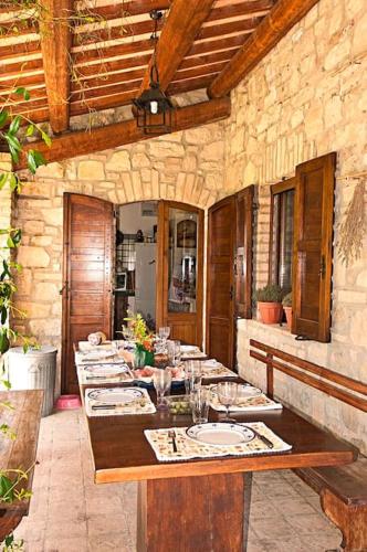 a dining room with a long table in a building at Villa I Camini - Outbuilding, dependance - Swimming pool - Garden - BBQ and fireplaces - Soccer field in Monte Castello di Vibio