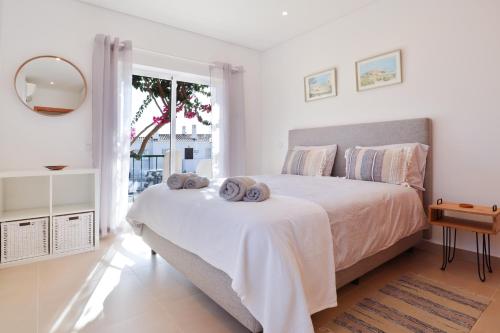 a bedroom with a large bed with towels on it at Casa Rujo - Waterside Village House in Luz