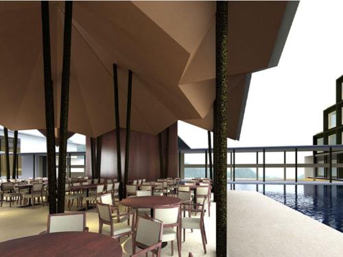 a restaurant with tables and chairs and a pool at Marasa Sarovar Premiere in Tirupati