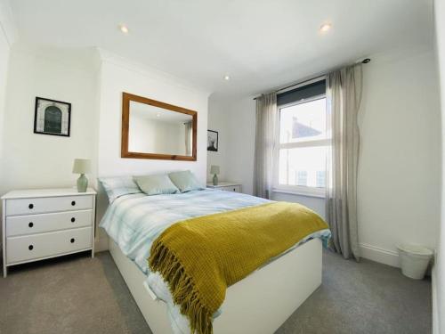 um quarto branco com uma cama e uma janela em Castle View 2 Bedroom Apartment in Town Centre em Hastings