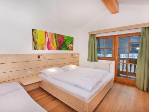 a bedroom with two beds and a large window at Apartment in Wald near Ski Slopes in Wald im Pinzgau