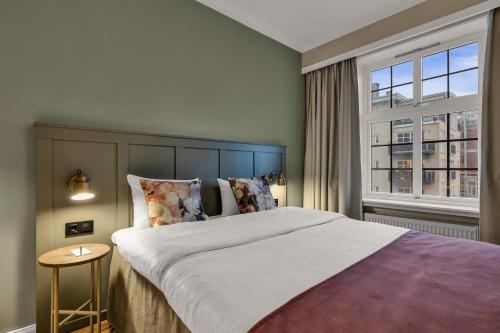 a bedroom with a large bed and a window at Home Hotel Gabelshus in Oslo