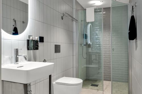 a bathroom with a toilet and a sink and a shower at Clarion Collection Hotel Gabelshus in Oslo