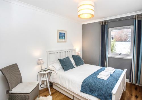 a bedroom with a bed and a chair and a window at Seahaven in North Berwick