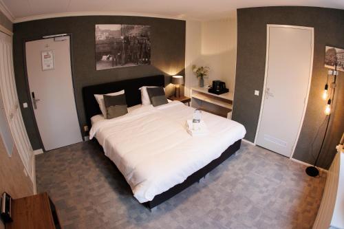 a bedroom with a large white bed in a room at Stadshotel Rijssen in Rijssen