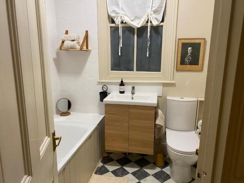 a bathroom with a sink and a toilet and a window at Stylish Apt London Excel Olympic close to station in London