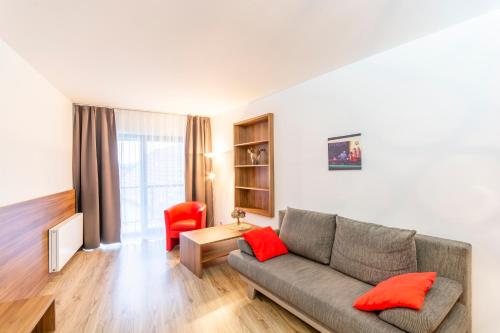 a living room with a couch and a red chair at Penzion Blatnička in Blatnička