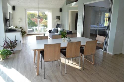 a dining room and living room with a table and chairs at Naturperlen in Rødekro