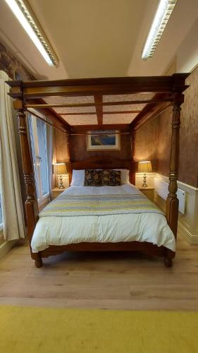 a bedroom with a large bed with a wooden canopy at 43A Crown Street in Halifax