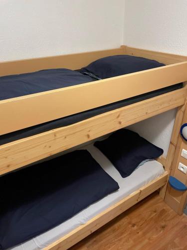ニースにあるLes Palmiersの木製の二段ベッド(青い枕付)